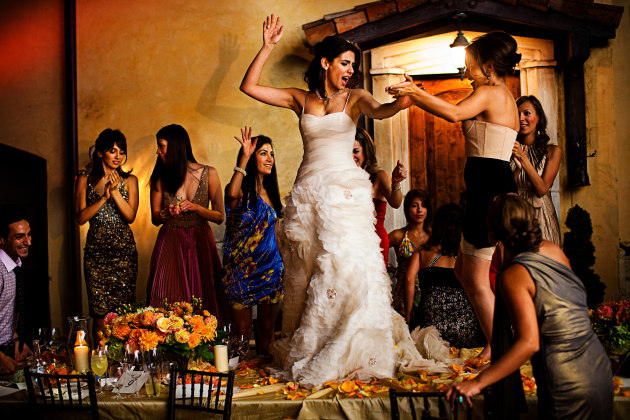 © Chrisman Studios. Persian bride dancing on table at wedding reception.
