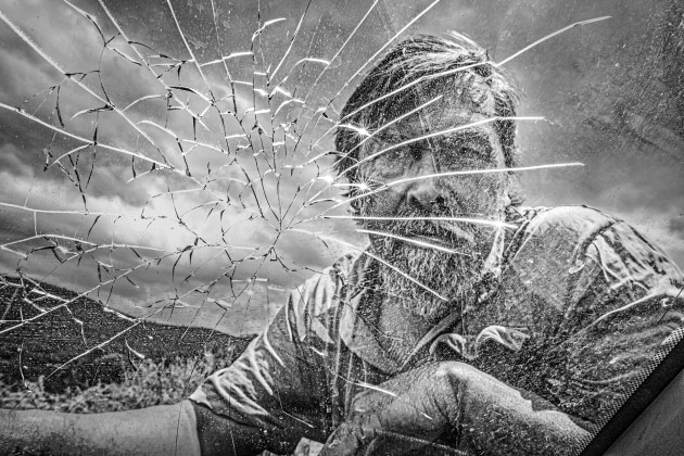 A farmer examines a broken car window in the Central Sierras, Cordoba &ndash; Argentina. Image &copy; Michael Coyne.