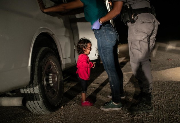 © John Moore/Getty images. A two-year-old Honduran asylum seeker cries as her mother is searched and detained near the U.S.-Mexico border on 12 June, 2018 in McAllen, Texas. The asylum seekers had rafted across the Rio Grande from Mexico and were detained by U.S. Border Patrol agents.