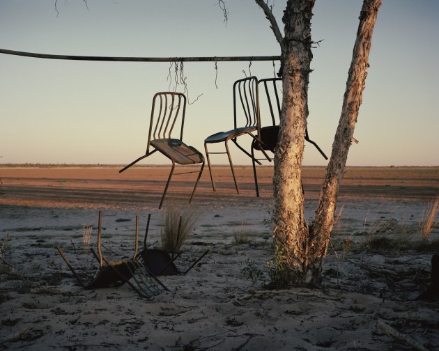 © Adam Ferguson. Chairs hang from a tree to secure them from flash flooding on Lake Huffer, a cattle Station in remote Queensland, Australia, 2017.