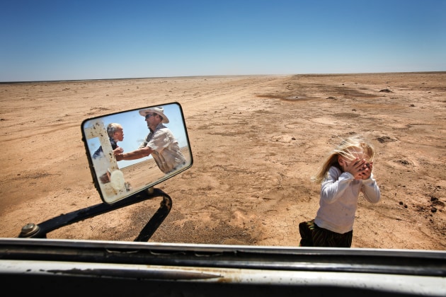 © Amy Toensing. Simon Booth plays with his kids, Claire and Ryan, in a dried-up paddock on their farm 7February, 2008, in Balranald, New South Wales, Australia. Simon travelled out to his fields to see how the rainstorm the day before had affected his land. One area had received just under 2 inches, which was the most rain in one incident in over 10 years for his station.
