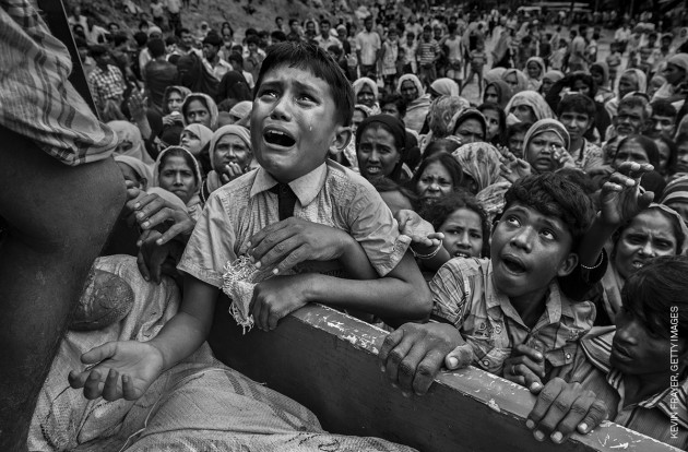 Rohingya Refugees Flee Into Bangladesh to Escape Ethnic Cleansing. &copy; Kevin Frayer, Getty Images.
GENERAL NEWS - SECOND PRIZE, STORIES
Attacks on the villages of Rohingya Muslims in Myanmar, and the burning of their homes, led to hundreds of thousands of refugees fleeing into Bangladesh on foot or by boat. Many died in the attempt. According to UNICEF, more than half of those fleeing were children. In Bangladesh, refugees were housed in existing camps and makeshift settlements. Conditions became critical; basic services came under severe pressure and, according to a M&eacute;decins Sans Fronti&egrave;res physician based there, most people lacked clean water, shelter and sanitation, bringing the threat of disease.
20 September 2017. A young refugee cries as he climbs on a truck distributing aid near the Balukhali refugee camp, Cox&rsquo;s Bazar, Bangladesh.